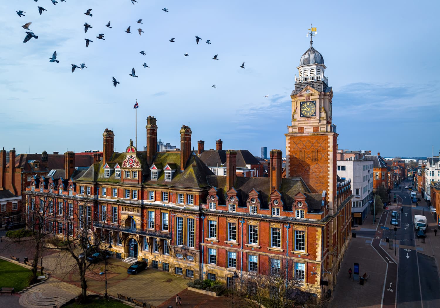 Photograph of Leicester University building with birds flying away